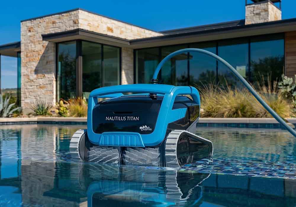 Dolphin Nautilus Titan waiting at the edge of a backyard pool with its cable